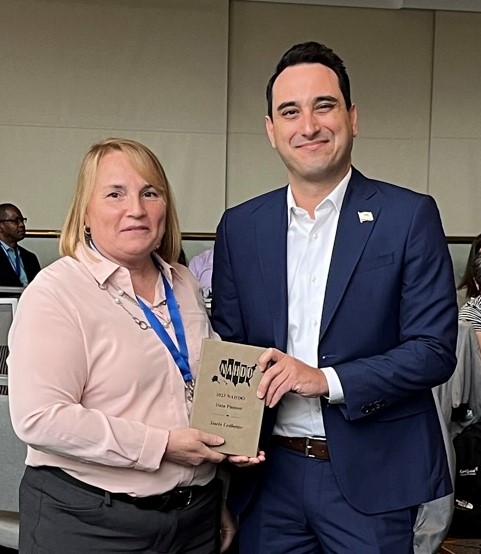 Michael Valle receiving an award from Janice Bourgault